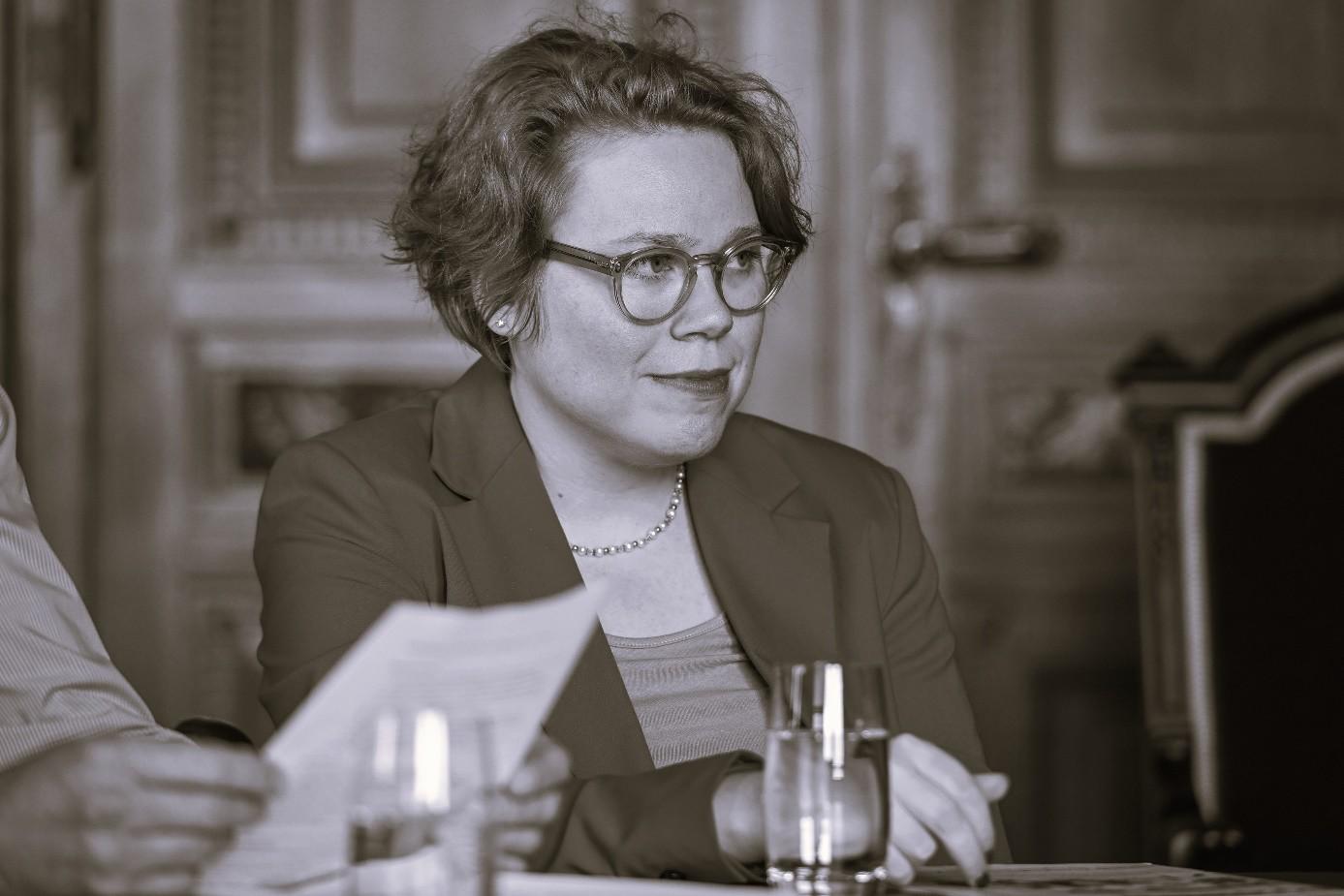 Schwarzweiss-Bild von Simone Feuerstein, an einem Tisch sitzend
